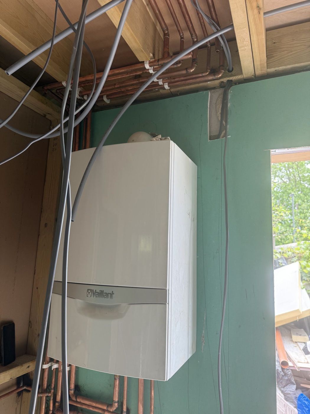 Duvara monte Vaillant kombi ve üstünden geçen bakır tesisat